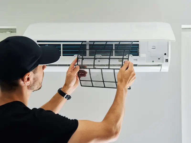 Contrôle du filtre d'une climatisation murale lors d'une visite d'entretien
