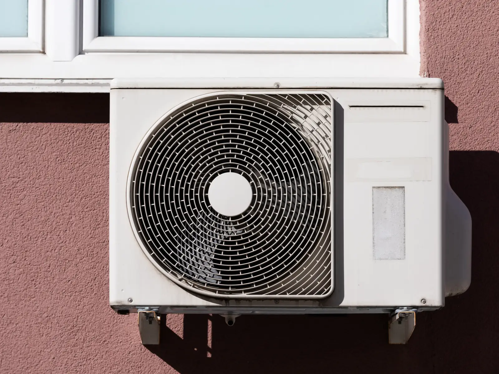 Groupe extérieur de climatisation fixé en façade d'une maison