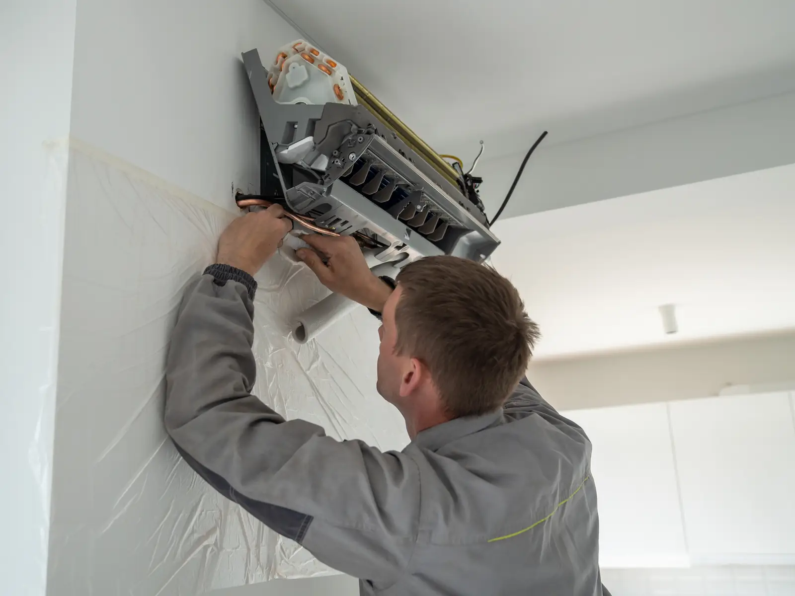 Installateur fixant un split mural, étape où la marque compte moins que la qualité de pose