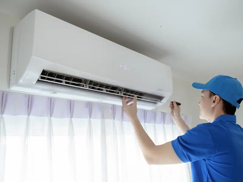 Technicien contrôlant le soufflage d'un climatiseur pour vérifier sa puissance réelle