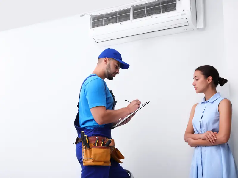 Technicien expliquant à une cliente l'origine de la panne de son climatiseur