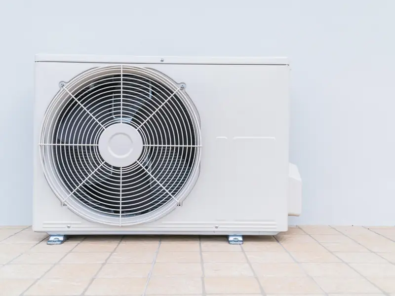 Unité extérieure de climatisation posée au sol sur un support dégagé