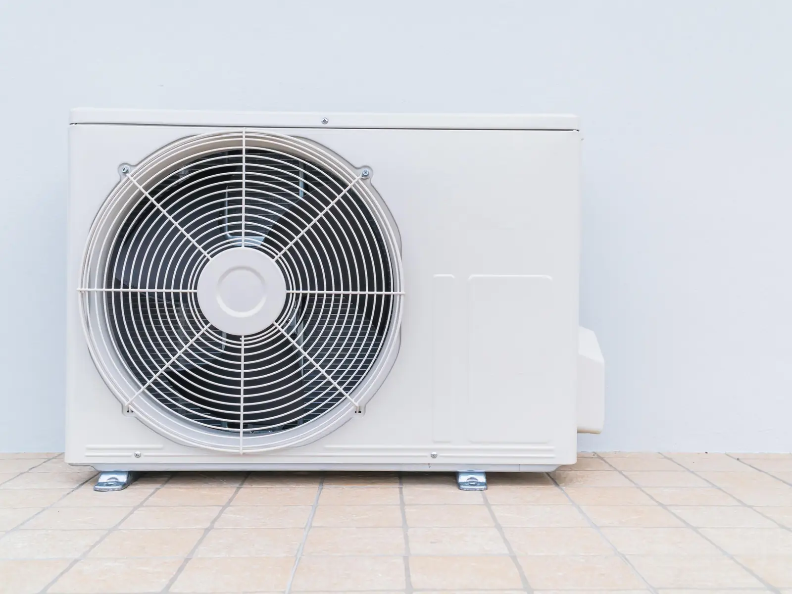 Unité extérieure de climatisation posée au sol sur une terrasse
