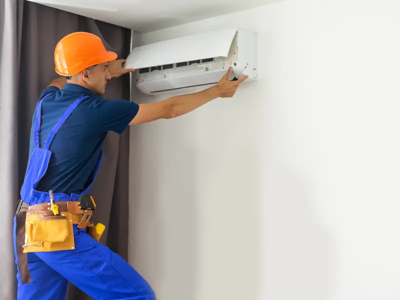 Installateur au travail sur une unité murale à Mougins